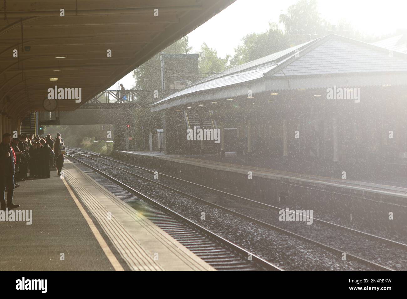 Commuters at Lisburn station wait for the Belfast bound Northern Ireland Railways service to arrive Stock Photo