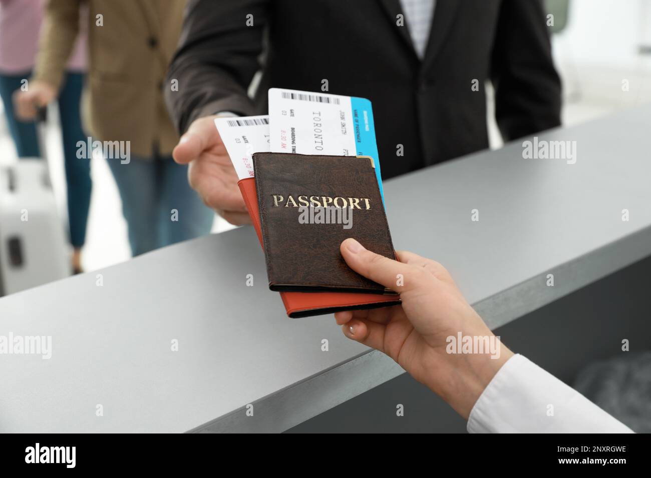 Agent giving passports and tickets to man at checkin desk in airport
