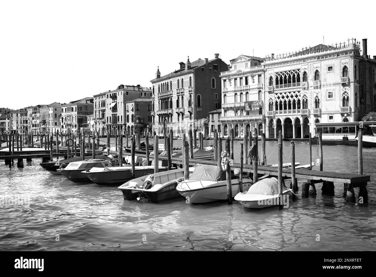 VENICE, ITALY - JUNE 13, 2019: View of Grand Canal with different boats at pier. Black and white tone Stock Photo