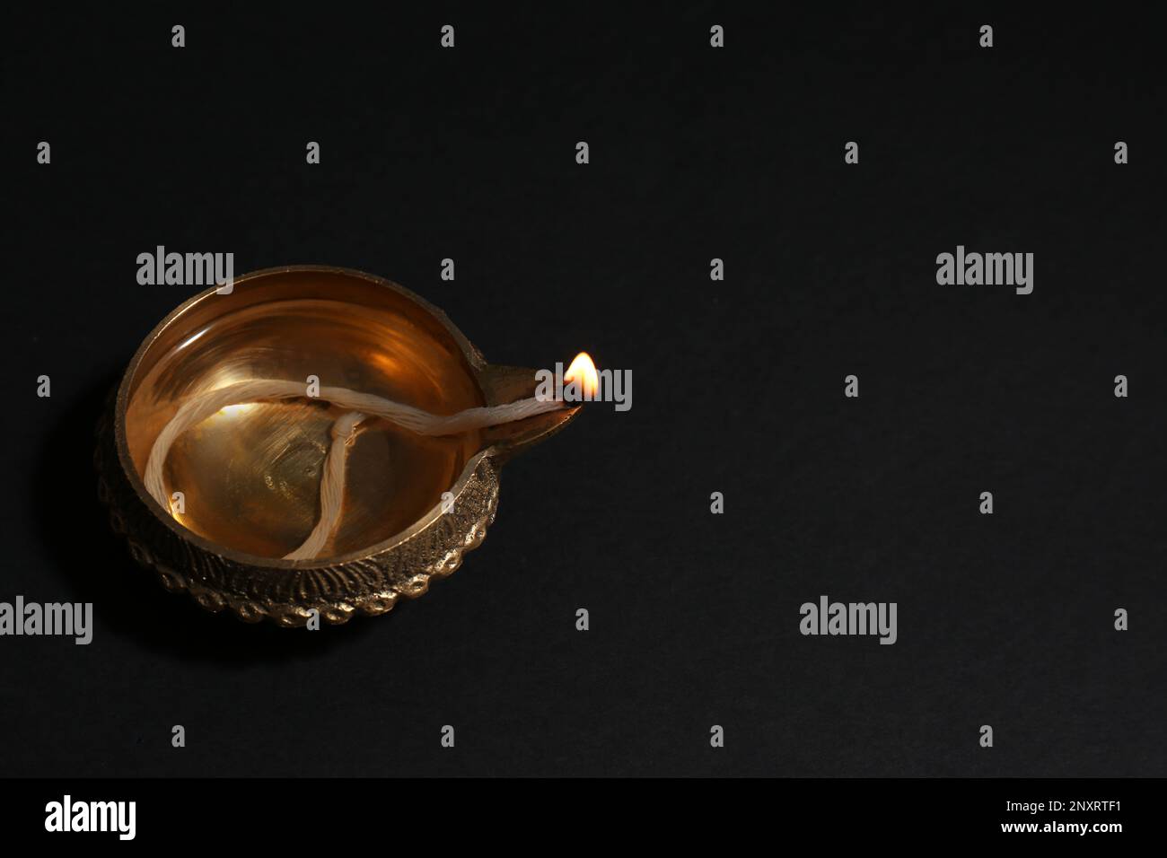 Lit diya on dark background, space for text. Diwali lamp Stock Photo