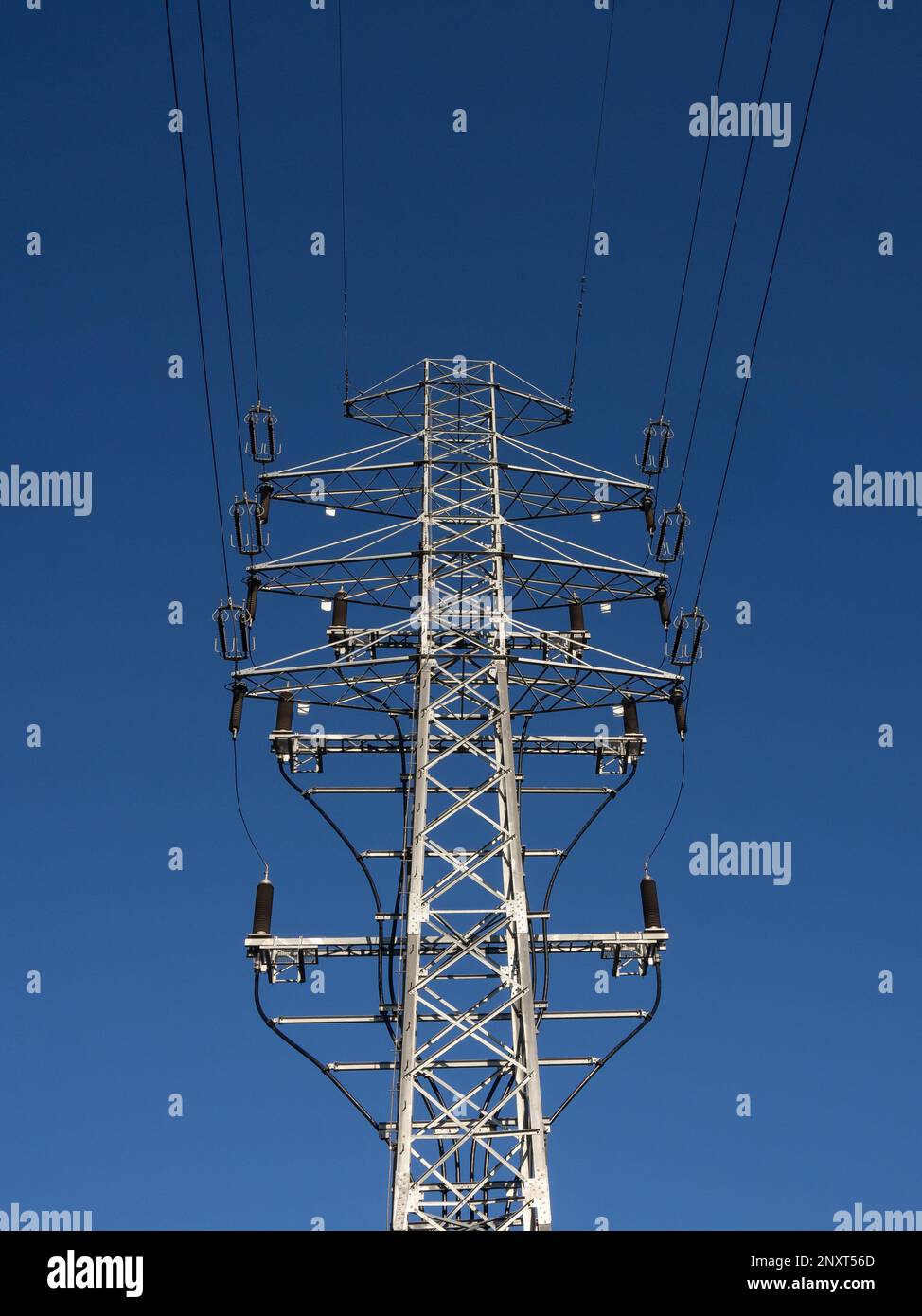 High voltage power pole on the background of blue sky. Stock Photo