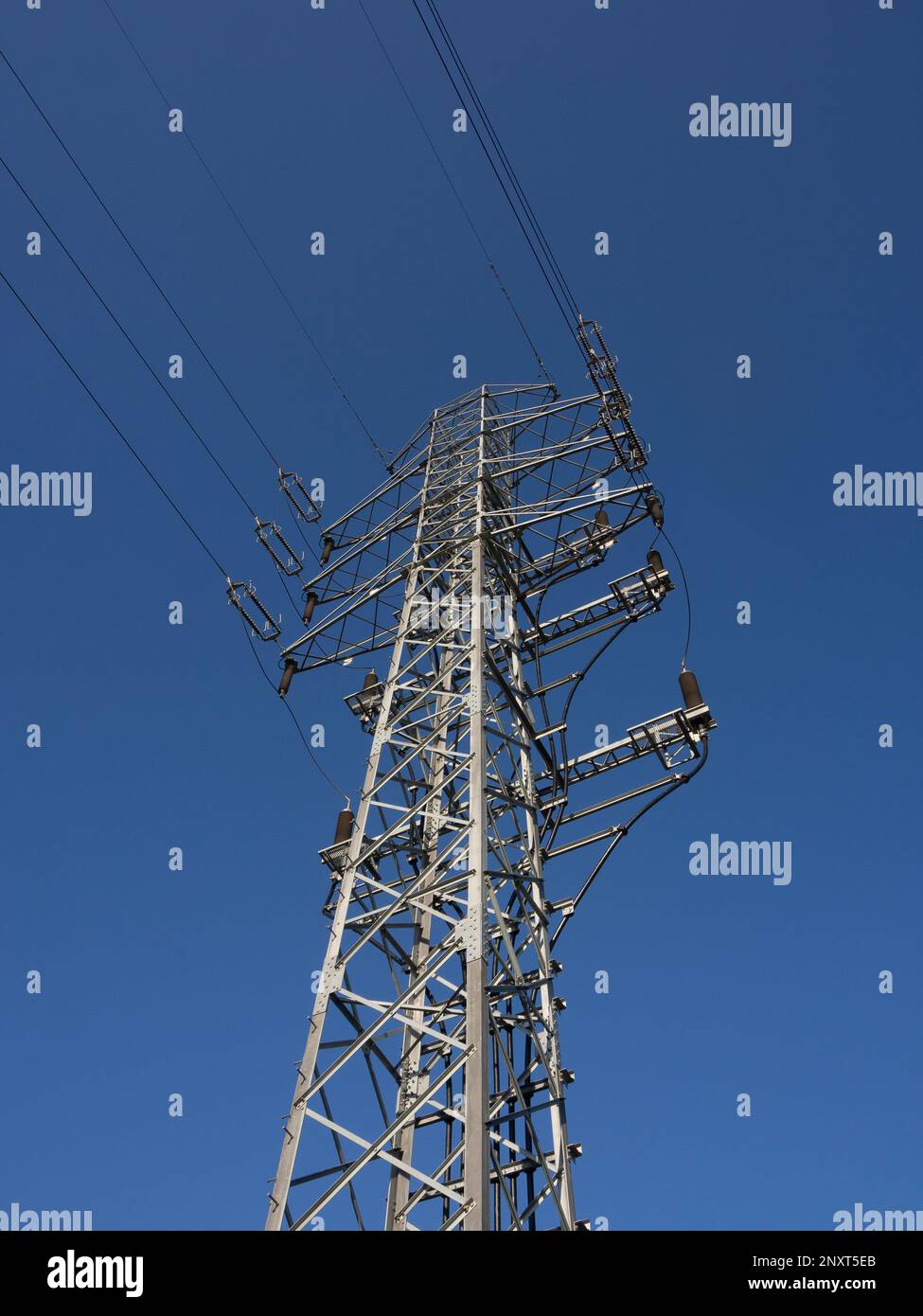 High voltage power pole on the background of blue sky. Stock Photo