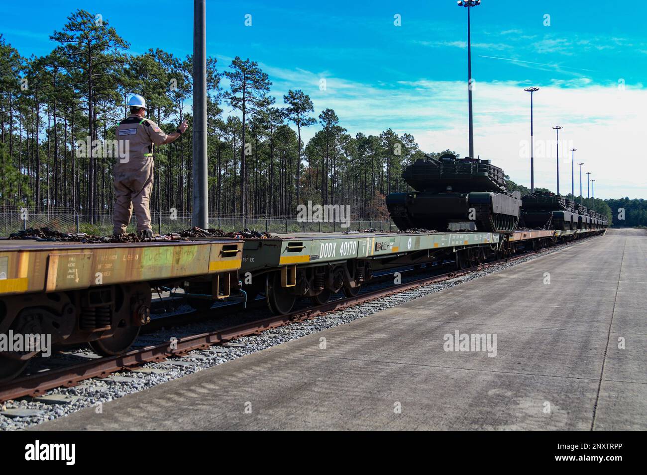 A General Dynamics employee guides an M1A2 SEPv3 Abrams tank off of a train at Fort Stewart; Georgia; Jan. 5; 2023. The M1A2 SEPv3 Abrams tank is a full-tracked; low-profile; land combat assault weapon enabling expeditionary Warfighters to dominate their adversaries through lethal firepower; unparalleled survivability; and audacious maneuver. Stock Photo