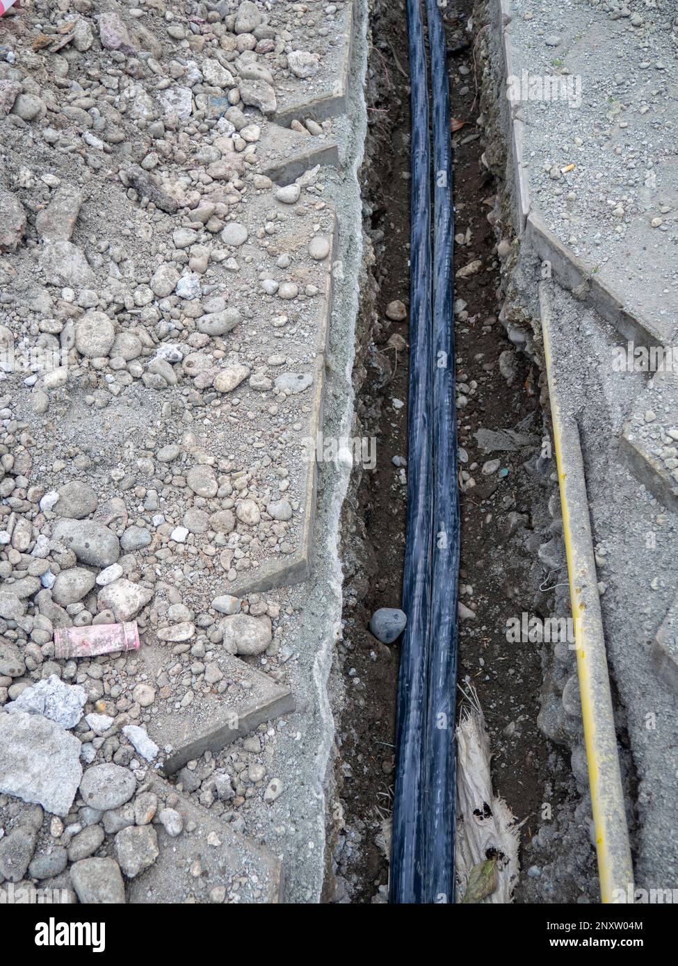 Broken sidewalk. Conducting the cable underground. Cable laying work