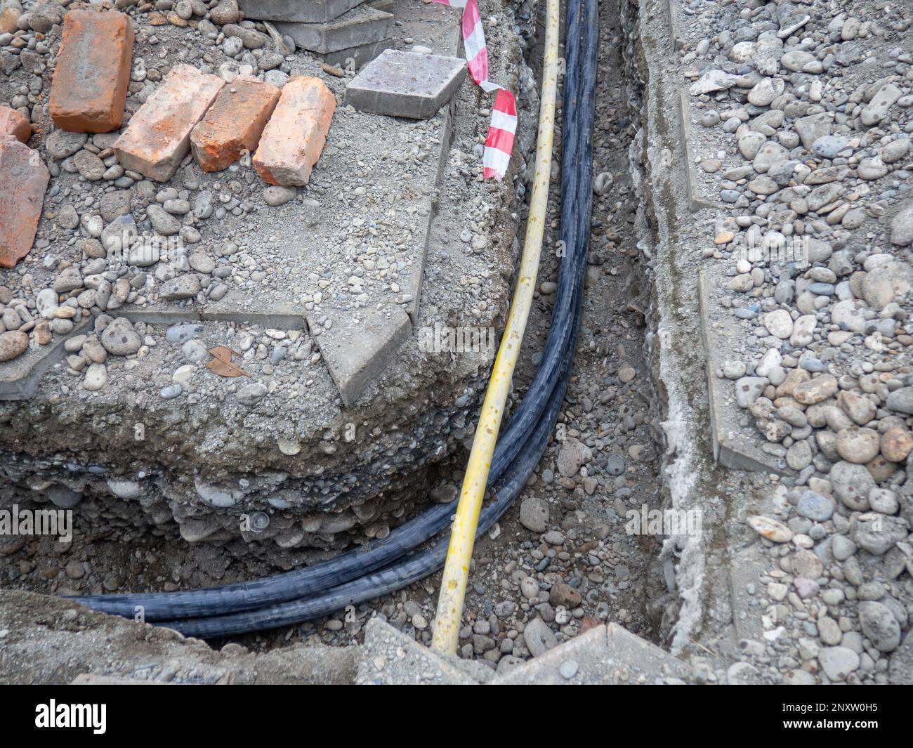 Broken sidewalk. Conducting the cable underground. Cable laying work