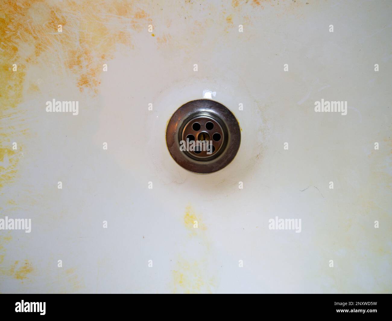 Mold on bathroom enamel. Black dots of mold and yellow plaque. Requires cleaning. Before using