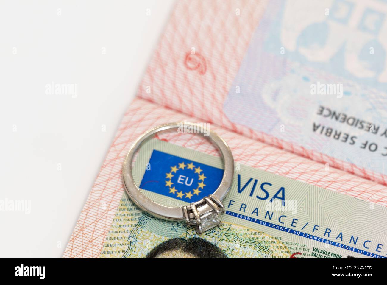 An engagement ring on a European visa stamp as a symbol of emigration or marriage Stock Photo