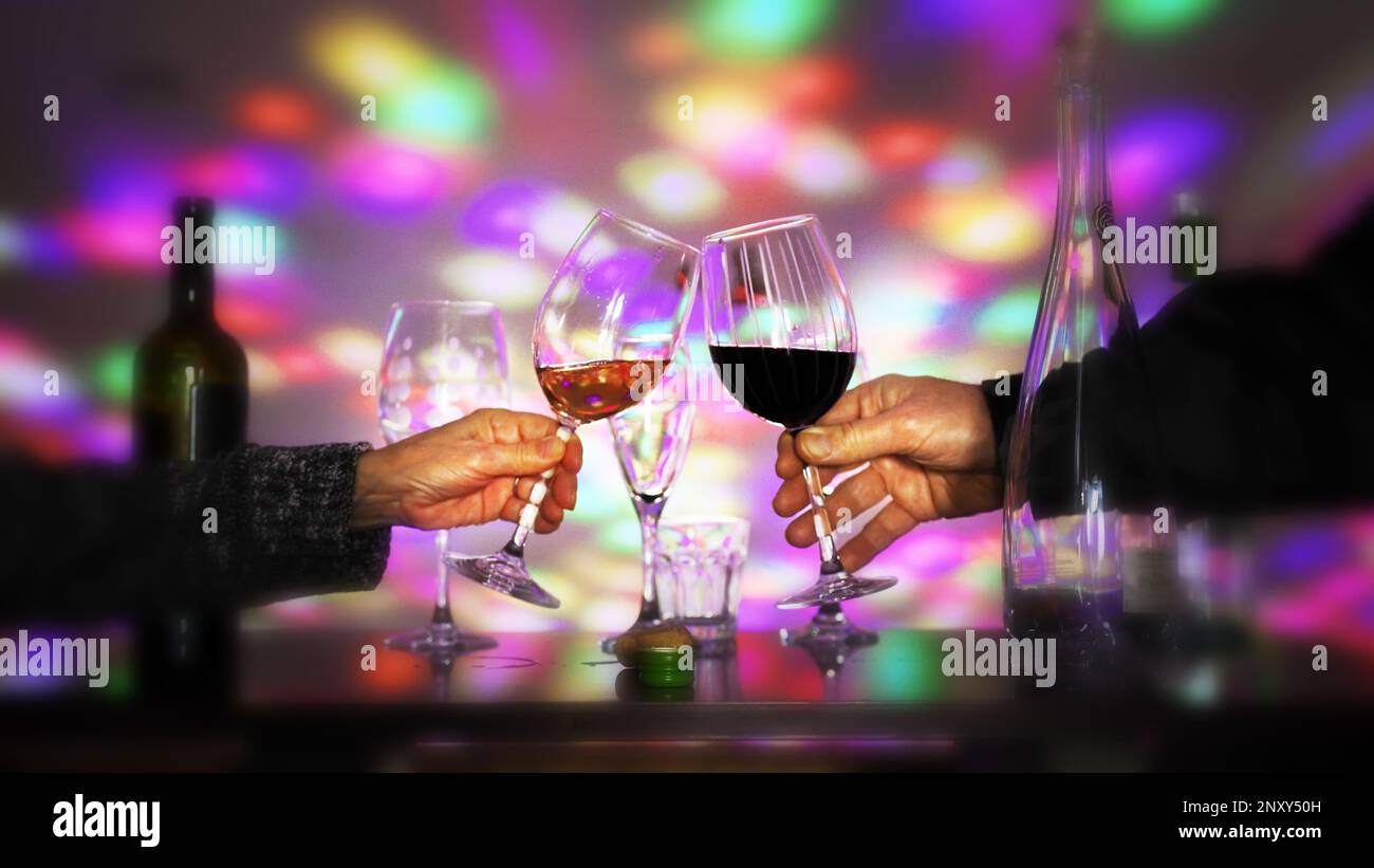 2 people clink their wine glasses in a bar Stock Photo