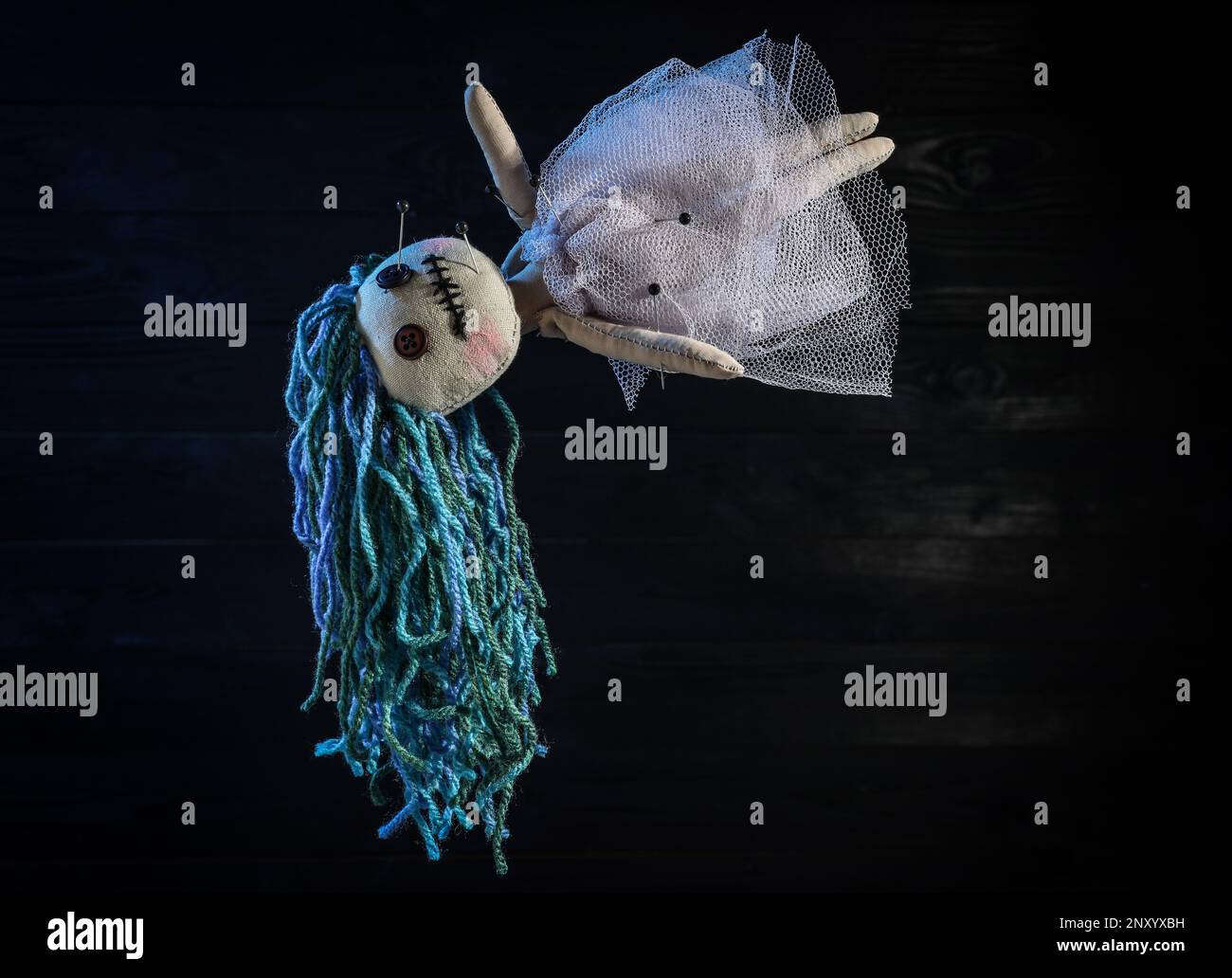 Female voodoo doll with pins on dark background Stock Photo - Alamy