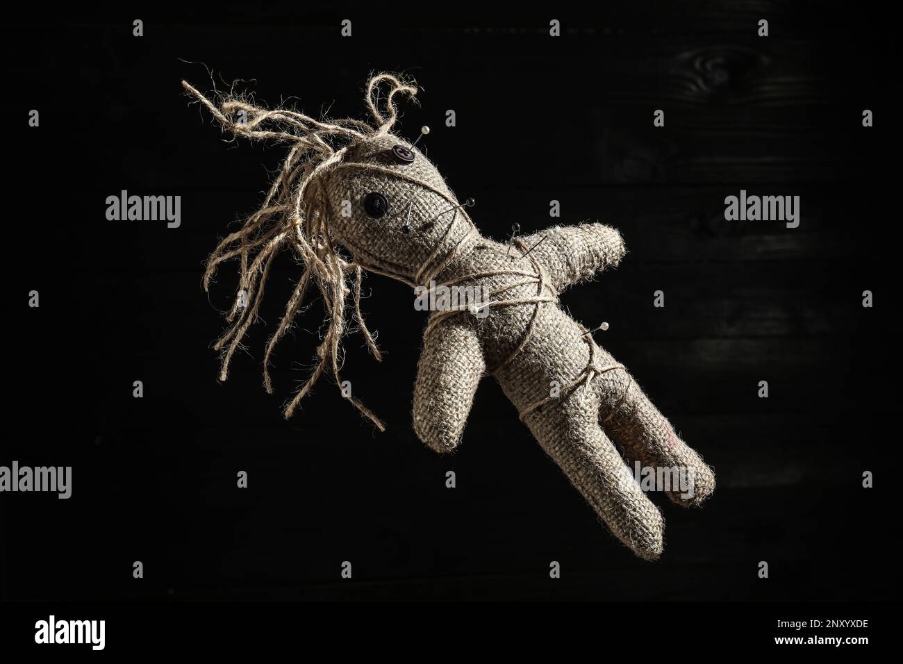 Female voodoo doll with pins on dark background Stock Photo - Alamy