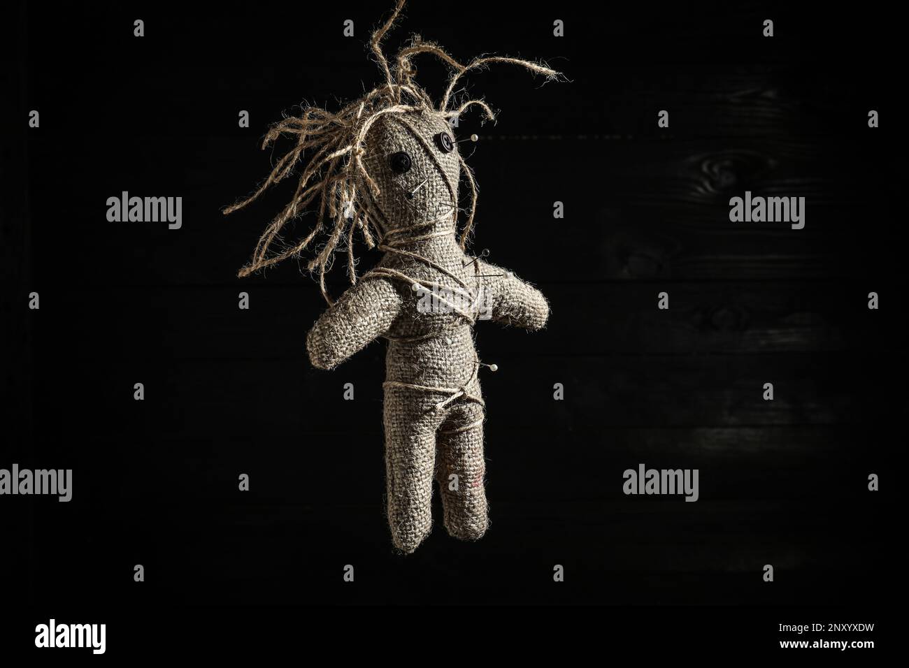 Female voodoo doll with pins on dark background Stock Photo - Alamy