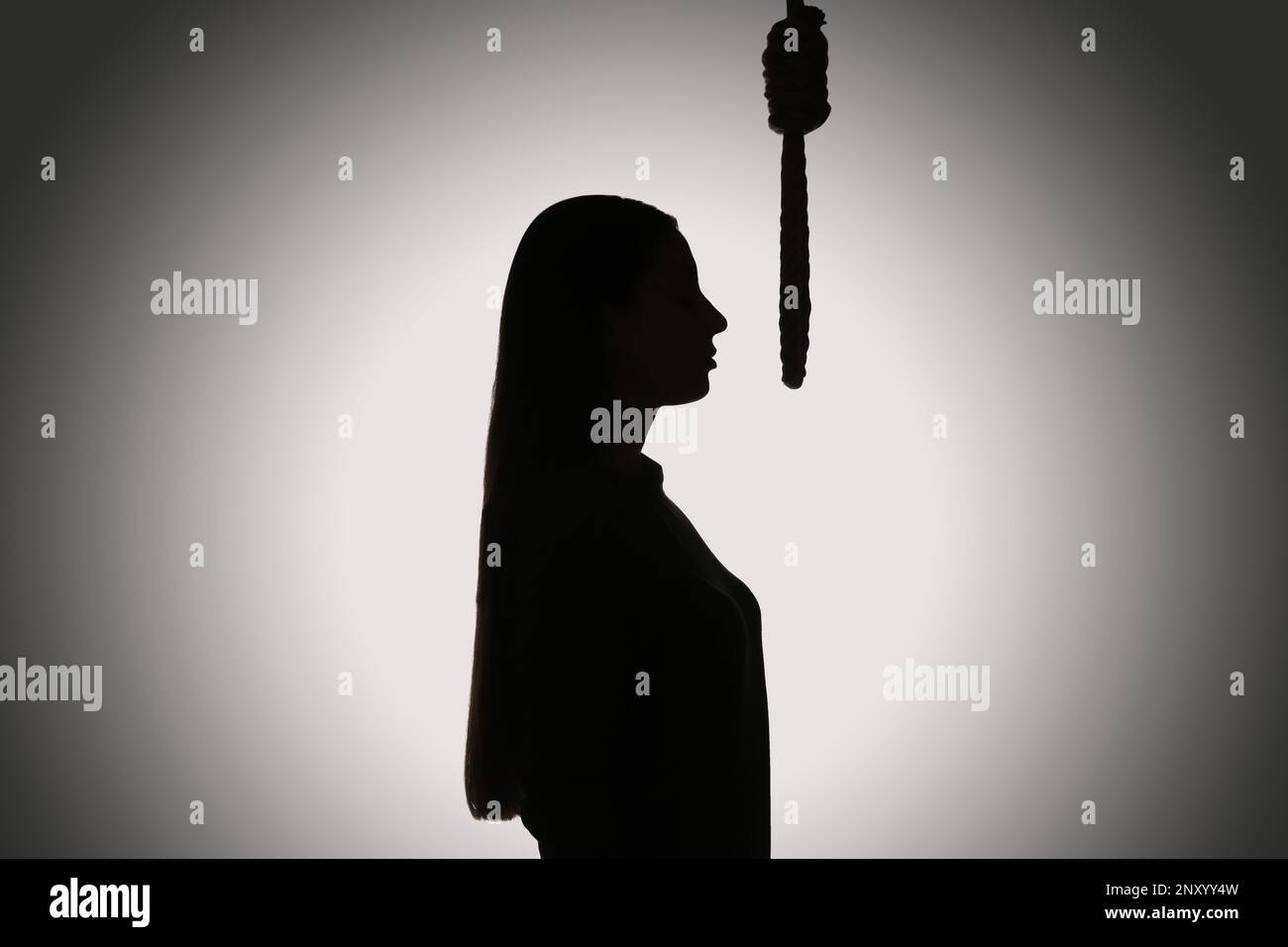 Silhouette of woman with rope noose on light background Stock Photo