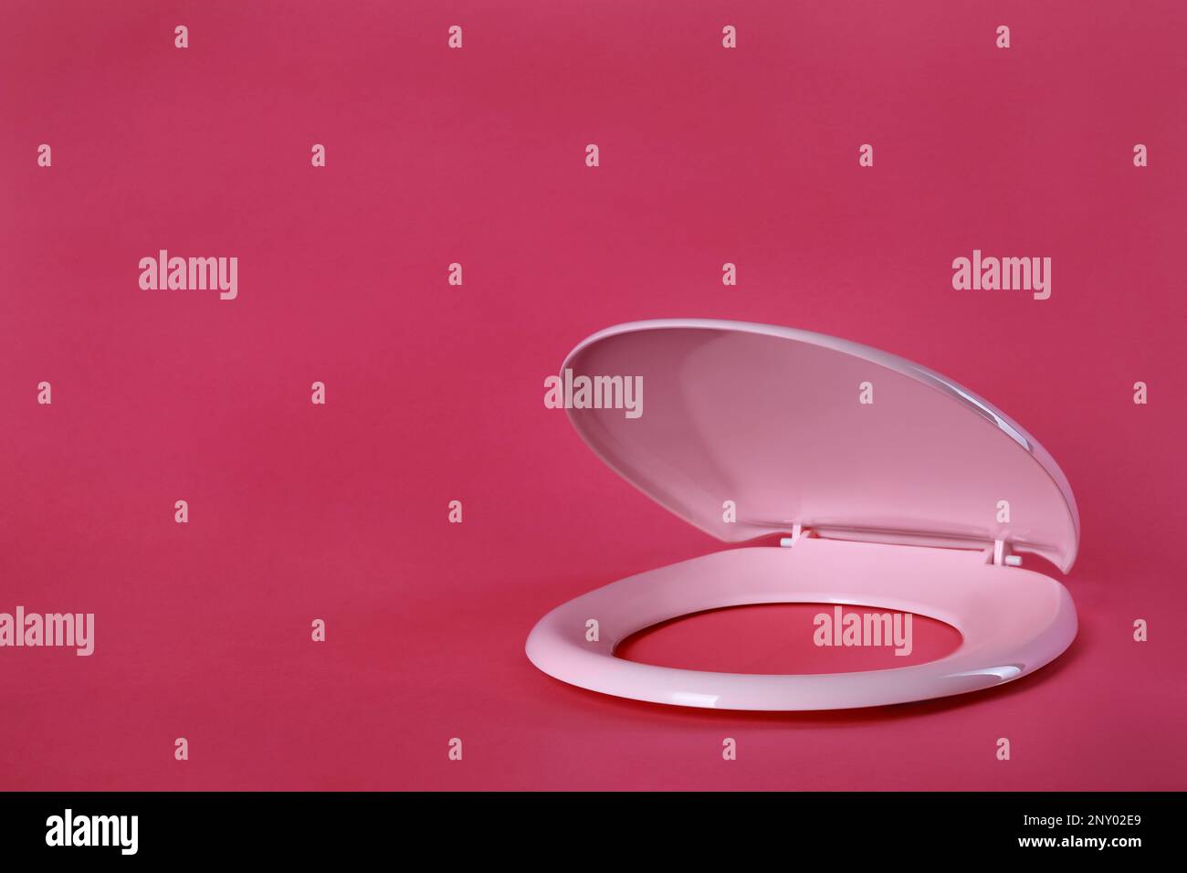 New plastic toilet seat on pink background, space for text Stock Photo