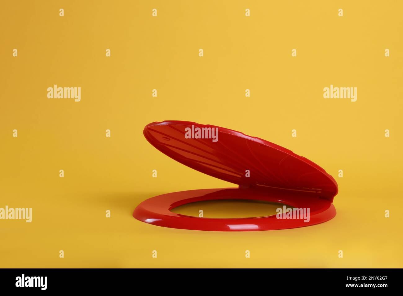 New red plastic toilet seat on yellow background Stock Photo Alamy
