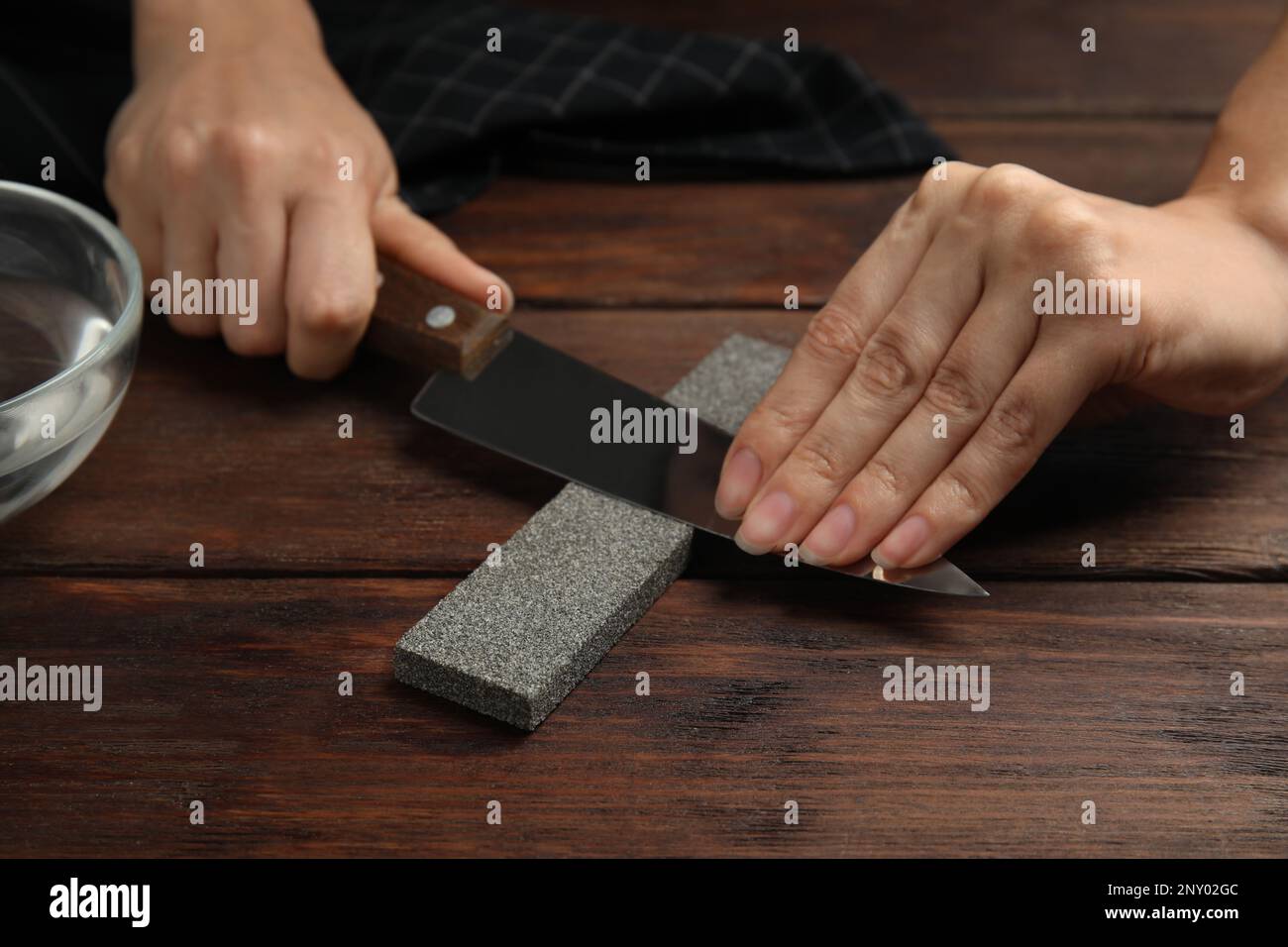 https://c8.alamy.com/comp/2NY02GC/woman-sharpening-knife-at-wooden-table-closeup-2NY02GC.jpg