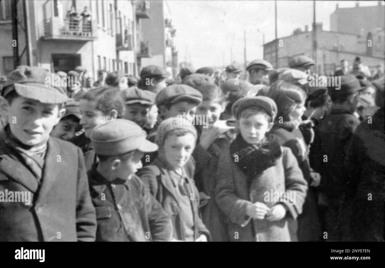 In the early stages of WW2 the Jews in nazi occupied europe were rounded up and forced into crowded ghettoes. When the decision was made to kill them all they were deported to extermination centres to be murdered. This image shows a gathering of children inside the ghetto. By Bundesarchiv, Bild 101III-Schilf-002-30 / Schilf / CC-BY-SA 3.0, CC BY-SA 3.0 Stock Photo