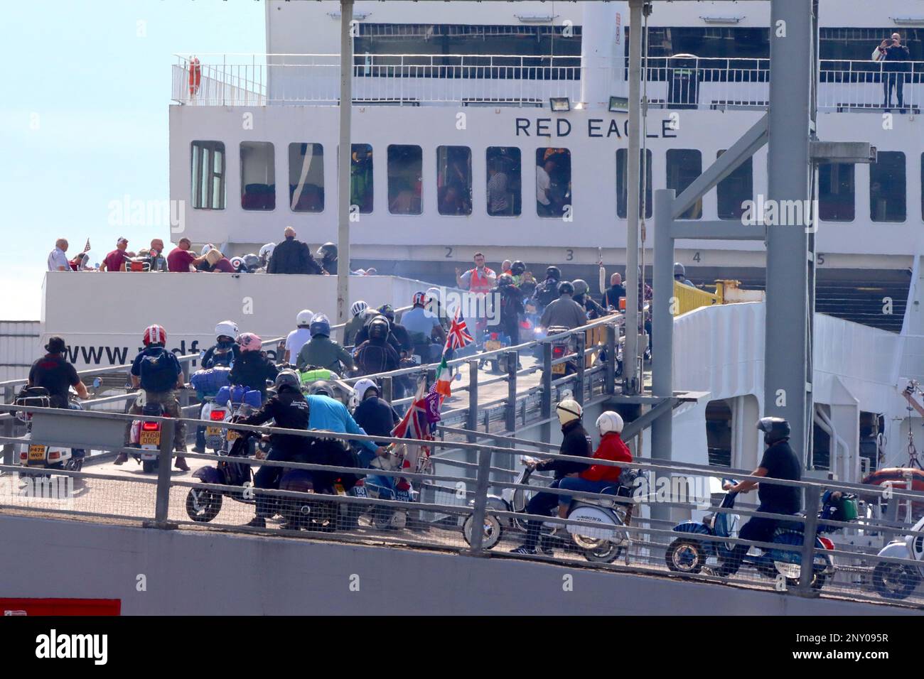 Vespas, Lambrettas, Royal Alloys, and replica classic scooters swarm upon the “Red Eagle” ferry, bound for the I-O-W scooter rally August 2022. Stock Photo