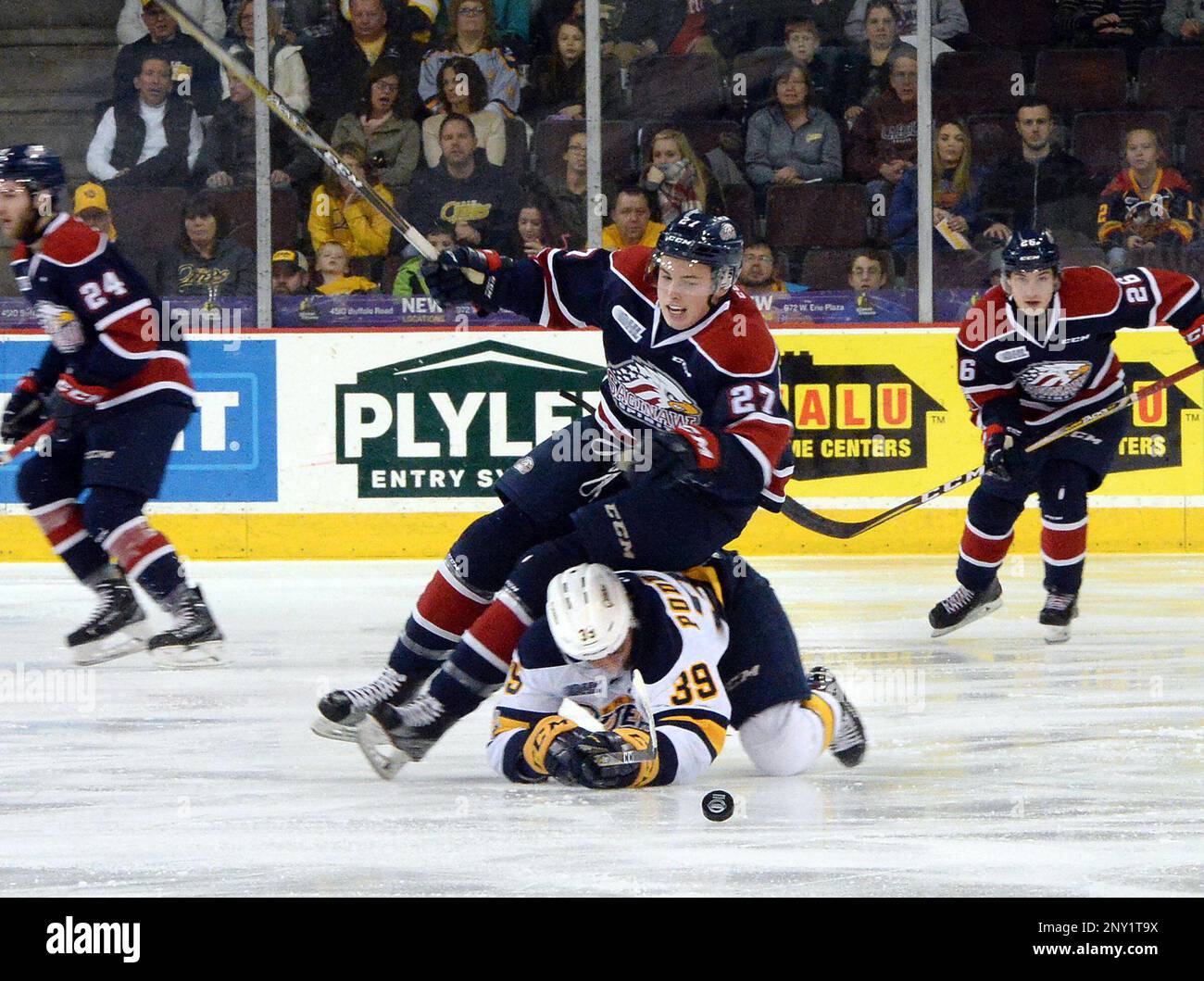 Saginaw Spirit forward Danny Katic, center, falls over Erie Otters forward Gera Poddubnyi during the first period of an OHL hockey game in Erie, Pa., Saturday, Nov