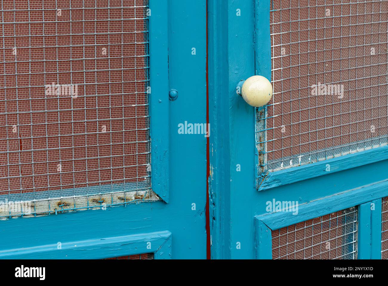 Antique ivory (or porcelain) door knob on an old wooden exterior screen