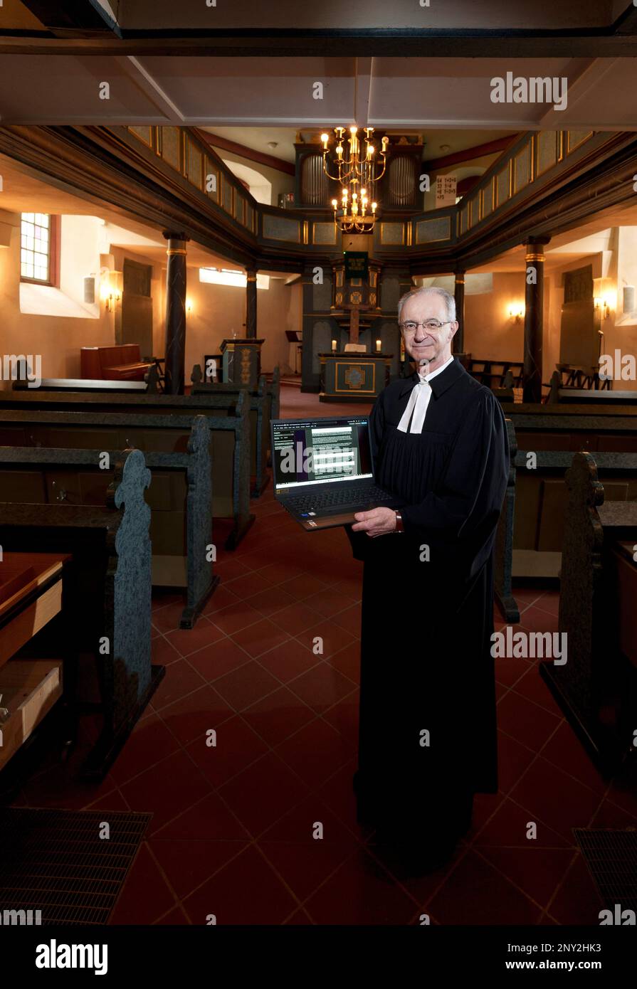 PRODUCTION - 24 February 2023, Hesse, Wiesbaden: Thomas Hartmann, pastor of the Protestant Thalkirche congregation, stands in the historic Thalkirche with his computer. The pastor is preaching with ChatGPT (Generative Pre-trained Transformer), a chatbot. A chatbot, or bot for short, is a text-based dialog system that allows chatting with a technical system.      (to dpa 'Pastor from Wiesbaden has sermons written with ChatGPT') Photo: Andreas Arnold/dpa Stock Photo