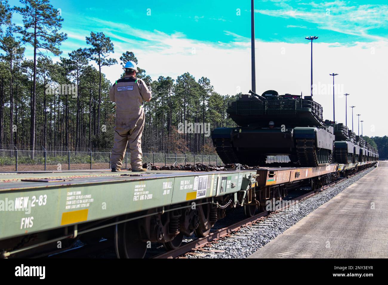 A General Dynamics employee guides an M1A2 SEPv3 Abrams tank off of a train at Fort Stewart, Georgia, Jan. 5, 2023. The M1A2 SEPv3 Abrams tank is a full-tracked, low-profile, land combat assault weapon enabling expeditionary Warfighters to dominate their adversaries through lethal firepower, unparalleled survivability, and audacious maneuver. Stock Photo
