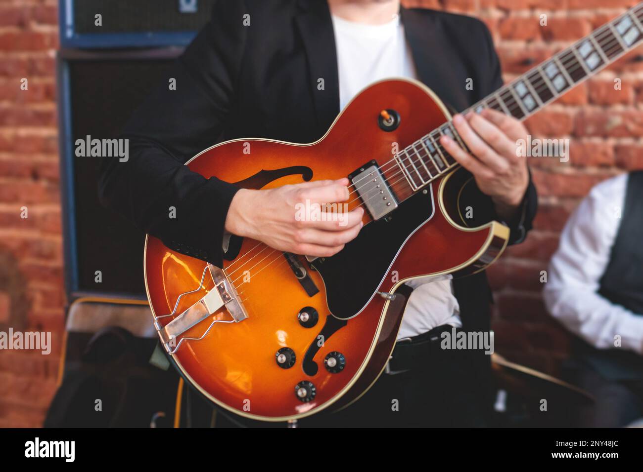 Concert view of an electric guitar player with vocalist and musical