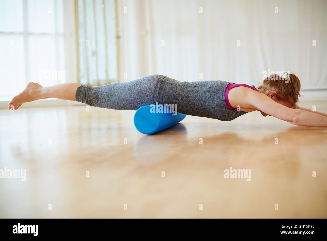 Doing some roller foam exercises to strengthen her muscles. a woman ...
