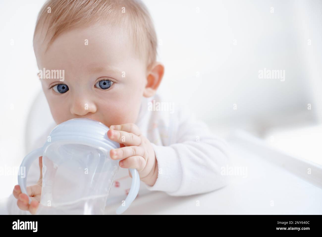 No more bottles for the big boy. Cropped image a cute baby boy drinking