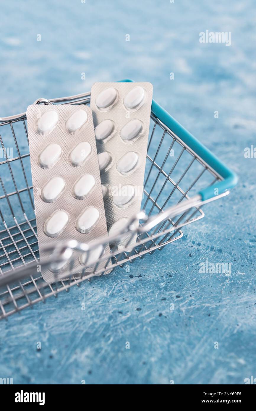 multivitamins pills or medicine tablets blister packs inside shopping basket, concept of cost of  healthcare and nutritional supplements Stock Photo