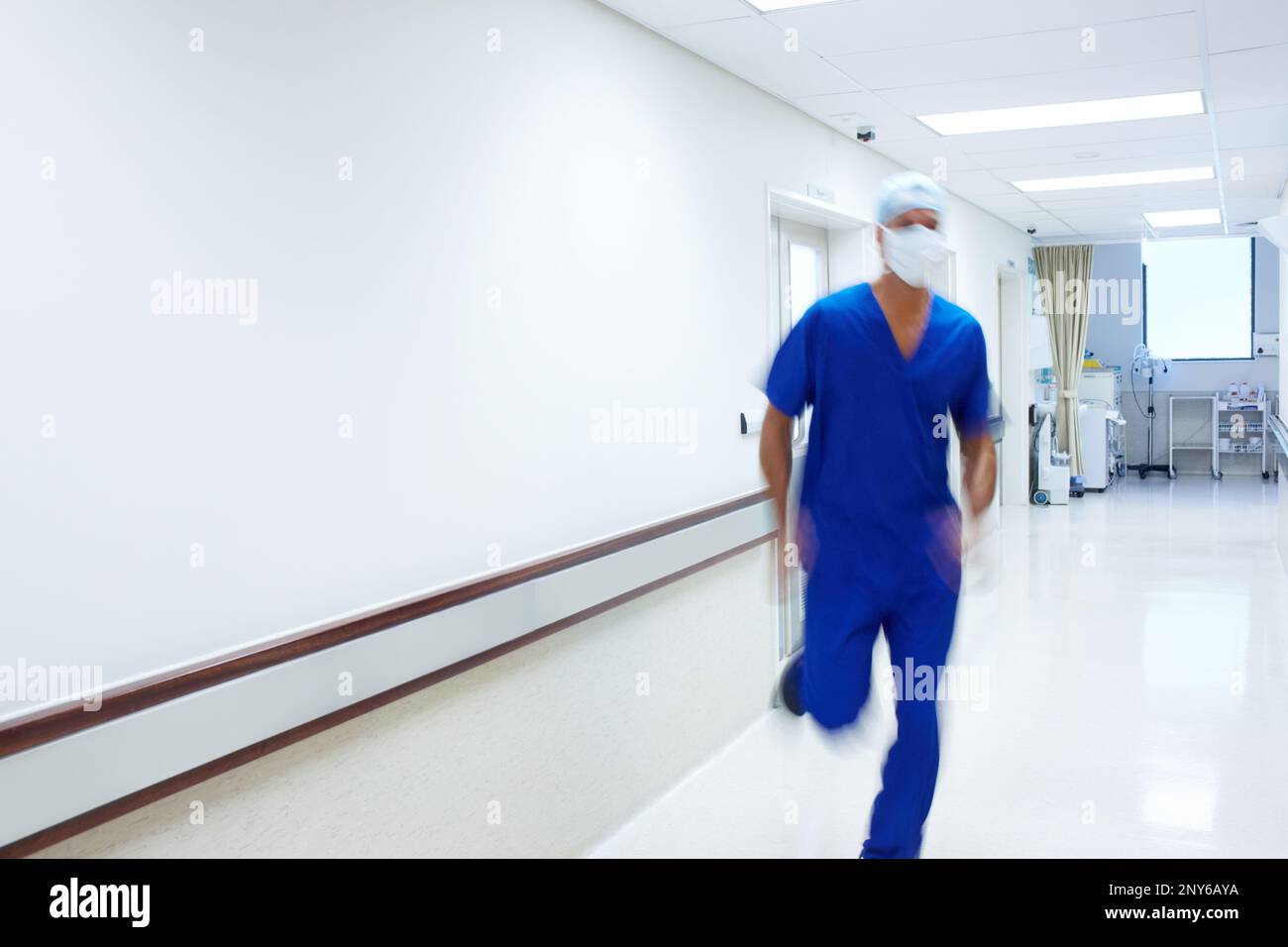 His patients rely on his quick actions. A doctor rushing in the passage of a hospital. Stock Photo