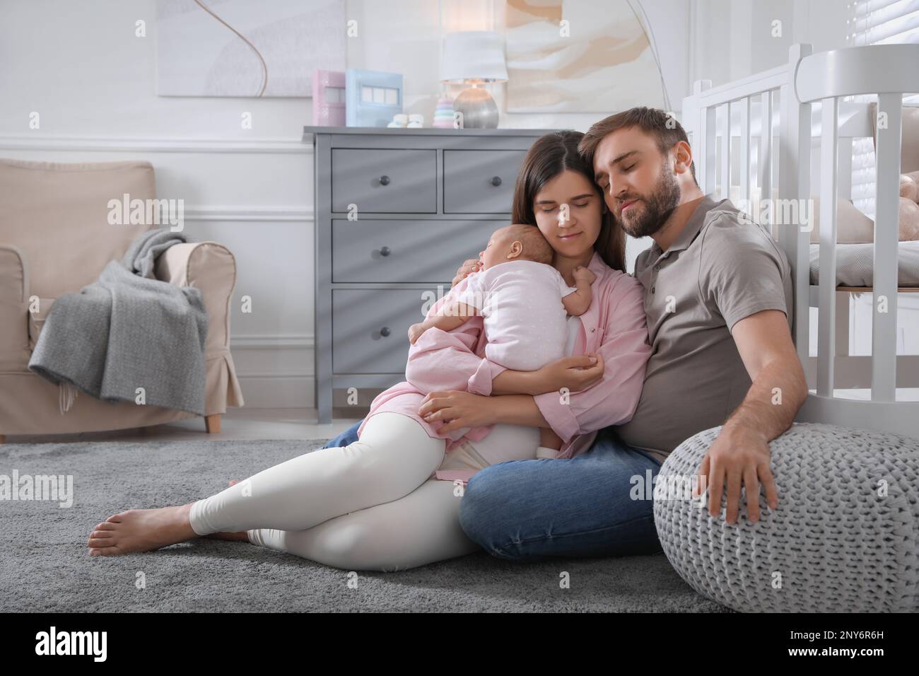 Tired young parents with their baby sleeping on floor in children's room Stock Photo Alamy