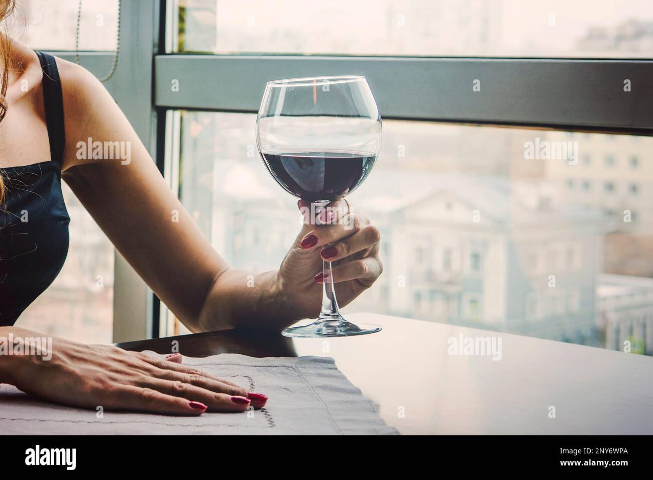 close up of young woman which her hand holding with glass red wine as a ...