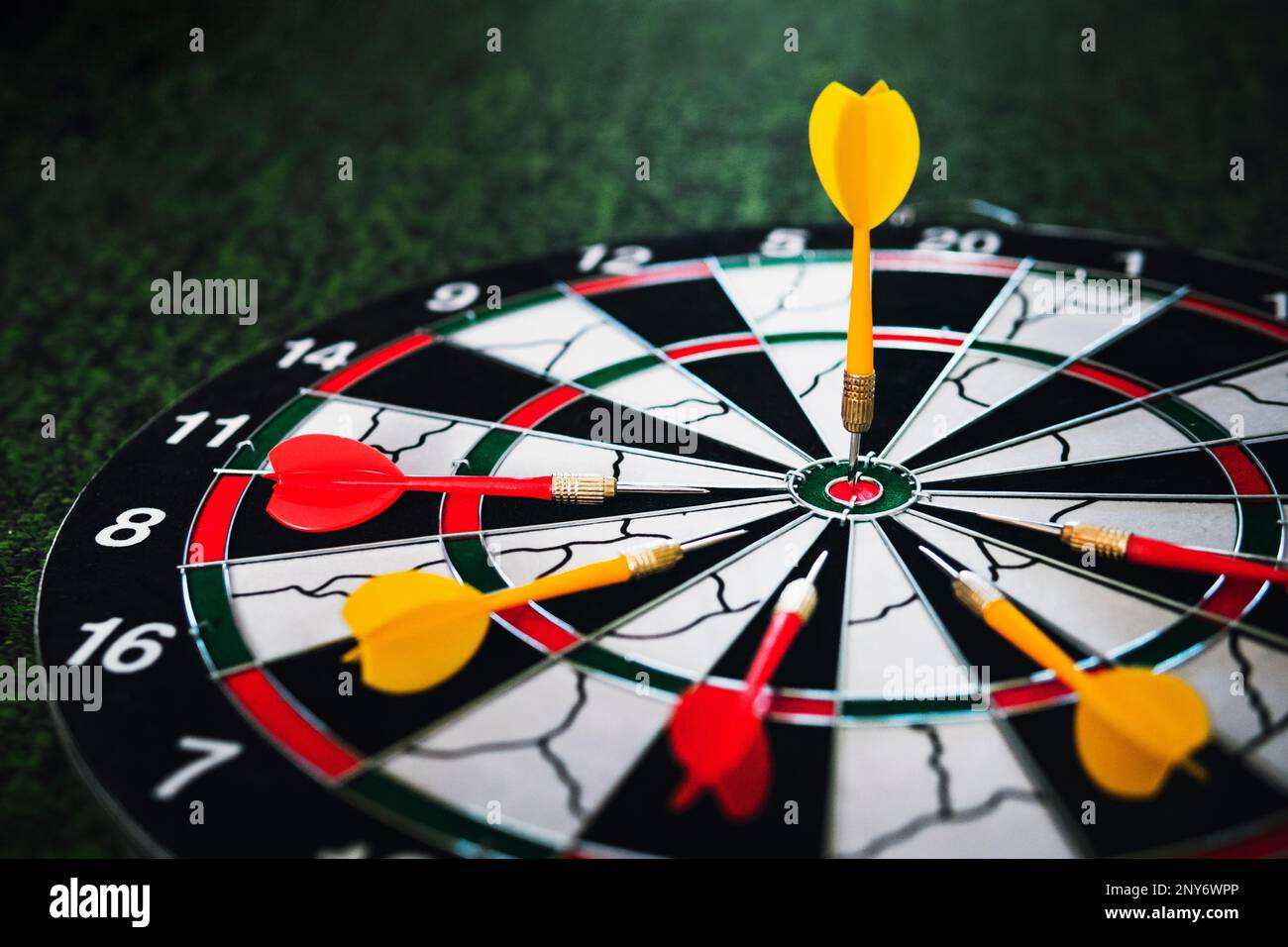 Close up shot of a dart board. Darts arrow Missing the target on a dart board during the game. Darts red and yellow. Stock Photo