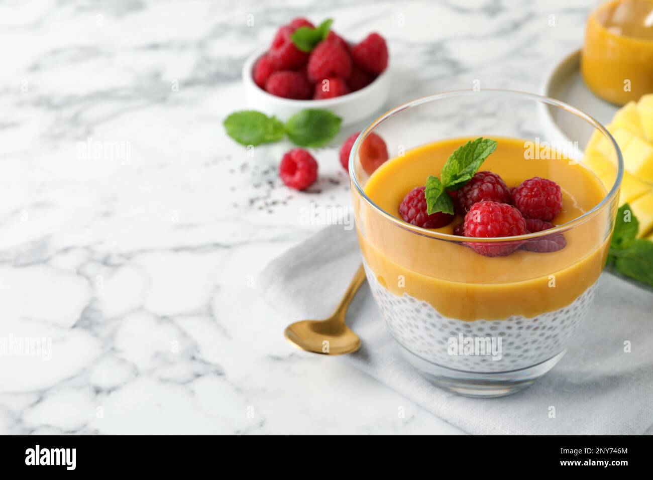 Delicious chia pudding with mango sauce and raspberries on white marble ...