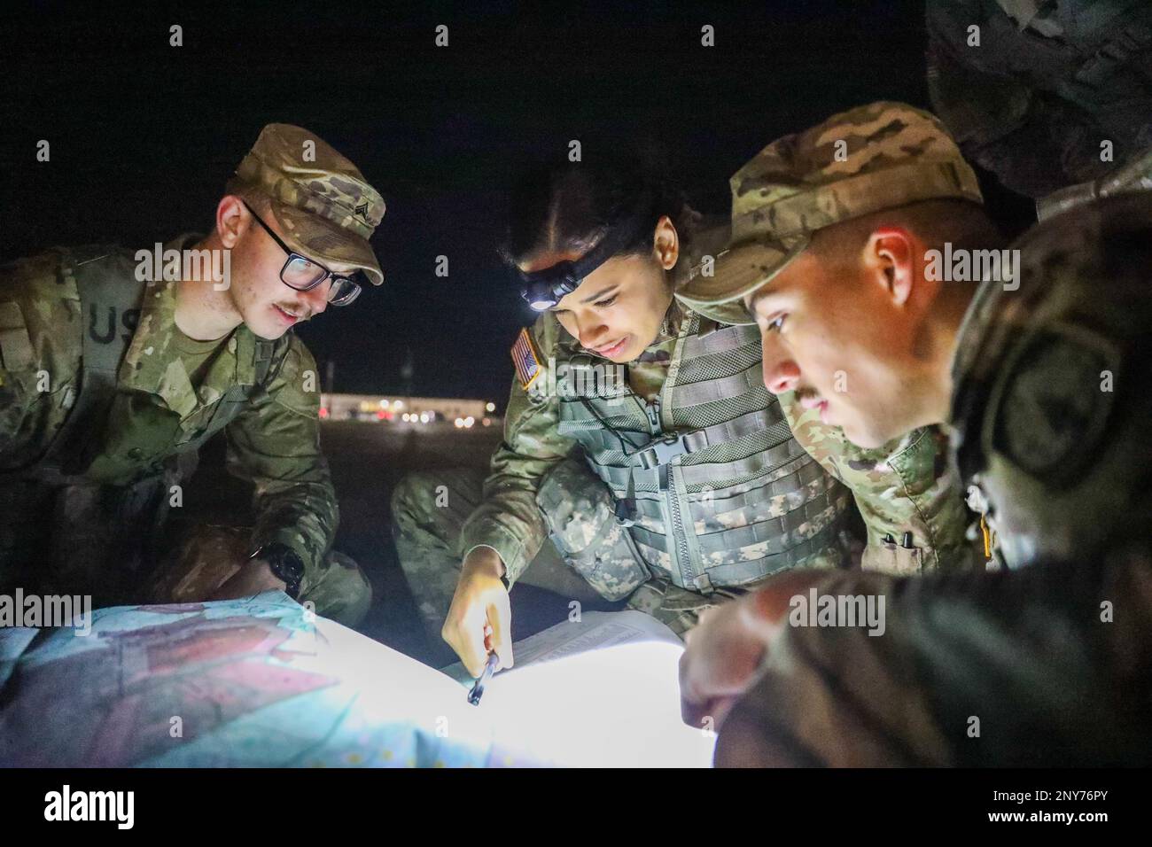 Sgt. Maximilian Lord, Spc. Brittani Schultz and Spc. Victor Graza, members of the 716th Military Police Battalion's Best Squad, discuss the quickest route towards their grid coordinates during the 16th Military Police Brigade Best Squad Competition on Fort Stewart, Georgia, Jan. 24, 2023. Competition events are a test of grit and toughness, foster readiness and esprit de corps, and are a fundamental part of building lethal, cohesive teams and expert leaders. Stock Photo