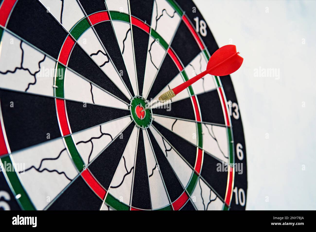 Close red dart on target board right frame. The red dart hit the target