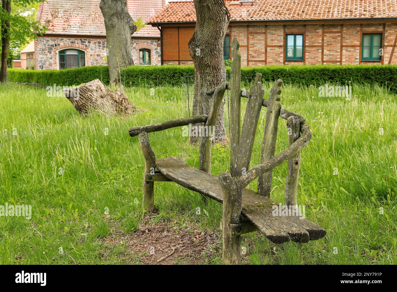 A wooden bench in the historic village Ihlow with old architecture in the background, federal State Brandenburg - Germany Stock Photo