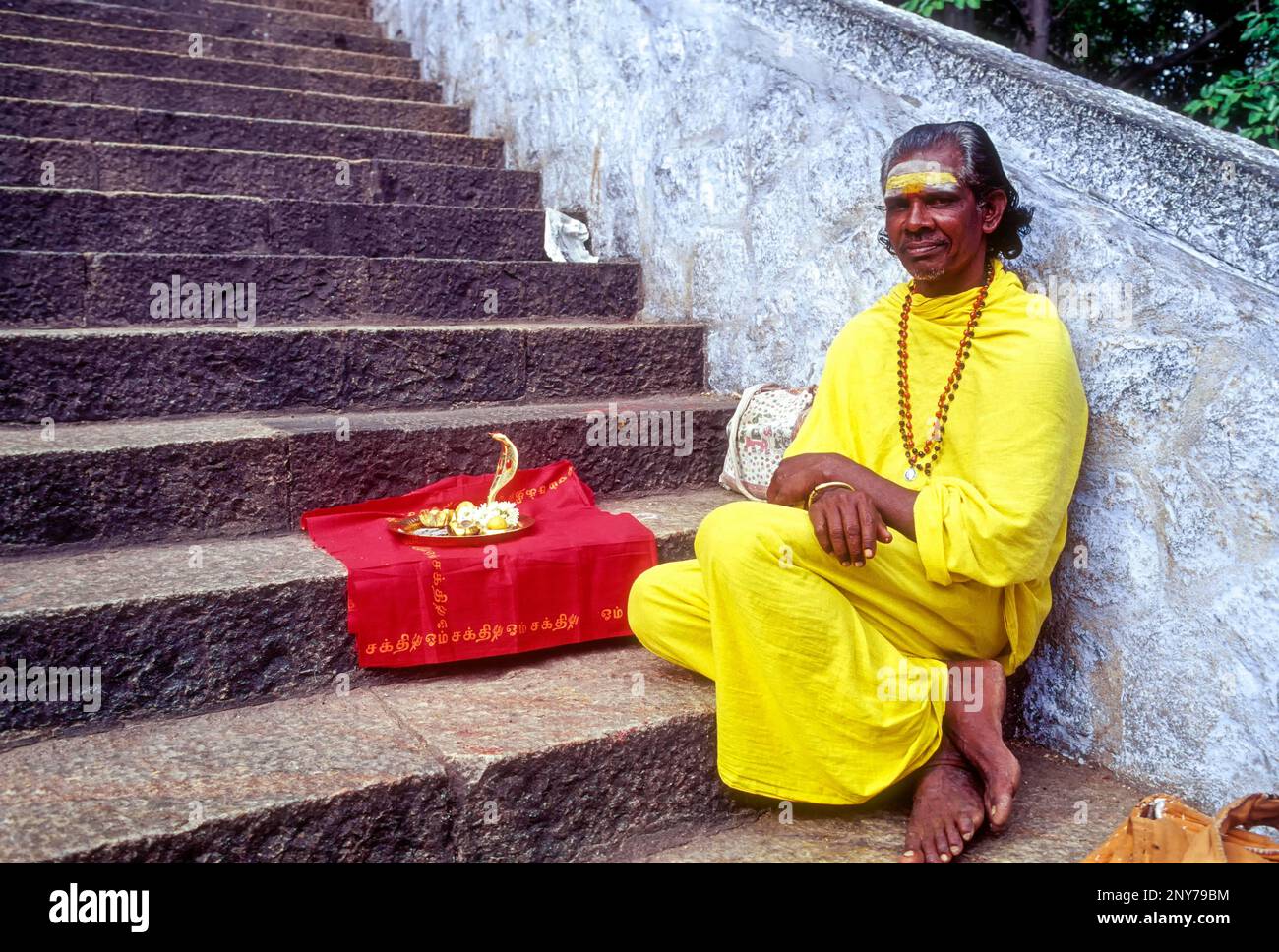 A Sadhu sitting on the steps of Arulmigu Dhandayuthapani Swamy Temple at Palani near Coimbatore, Tamil Nadu, India Stock Photo
