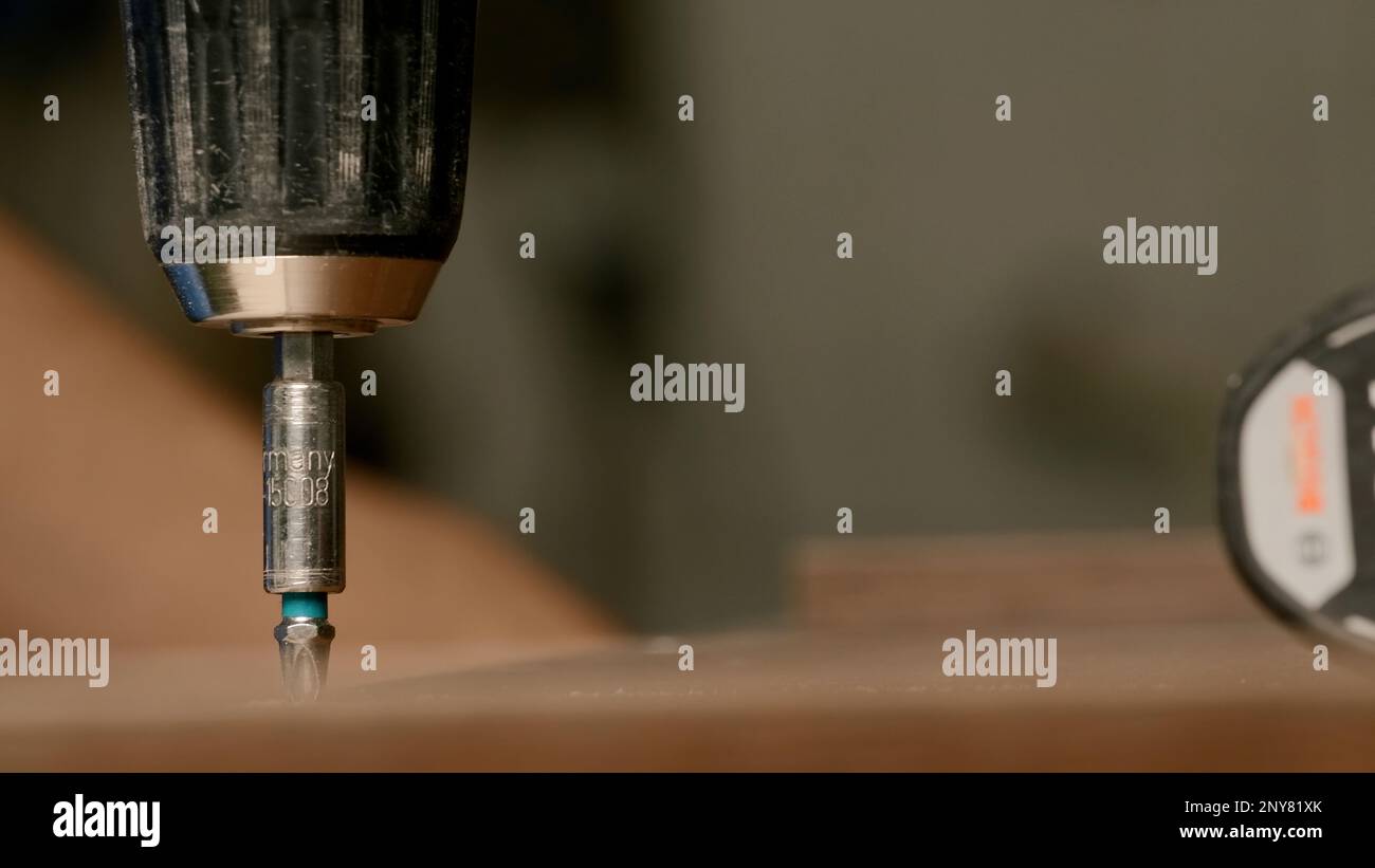 Close up of a man carpenter using screwdriver while working with a wooden product. Creative. Woodwork at the workshop Stock Photo