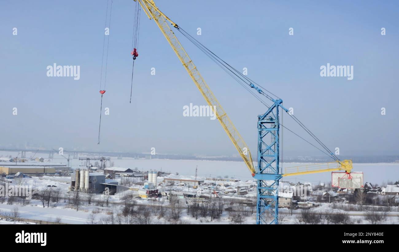 Industrial aerial background with the crane at the construction site. Clip. Winter frozen landscape, concept of heavy machinery Stock Photo