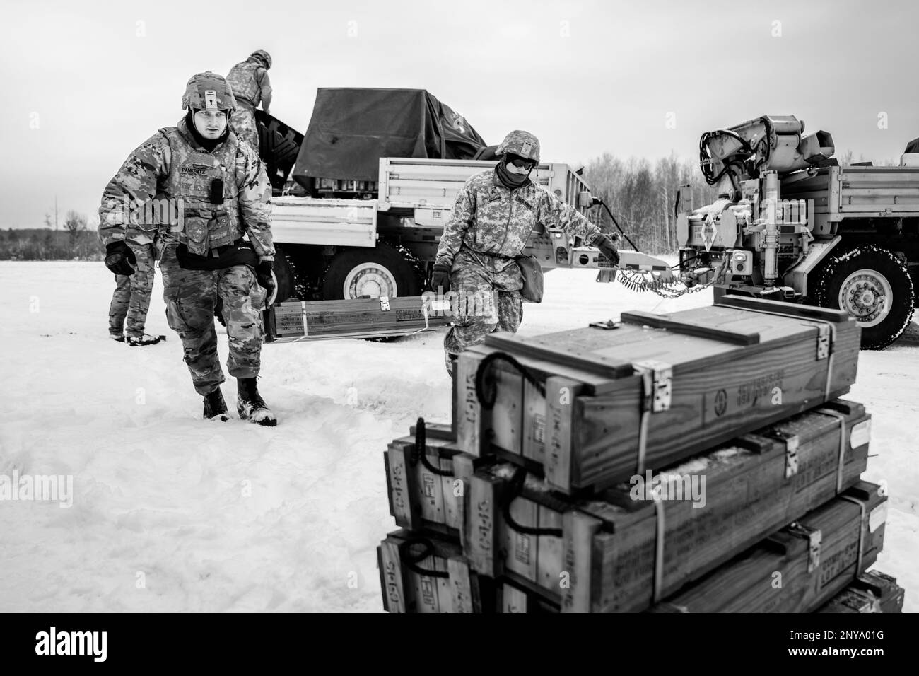 Army Sgt. Meranda Leisgana and Sgt. Trayton Pankratz, 1-120th Field Artillery Regiment, carries a wooden crate of 105mm High Explosive shells for the M119 howitzer during Northern Strike 23-1, Jan. 25, 2023, at Camp Grayling, Mich. Units that participate in Northern Strike’s winter iteration build readiness by conducting joint, cold-weather training designed to meet objectives of the Department of Defense’s Arctic Strategy. Stock Photo