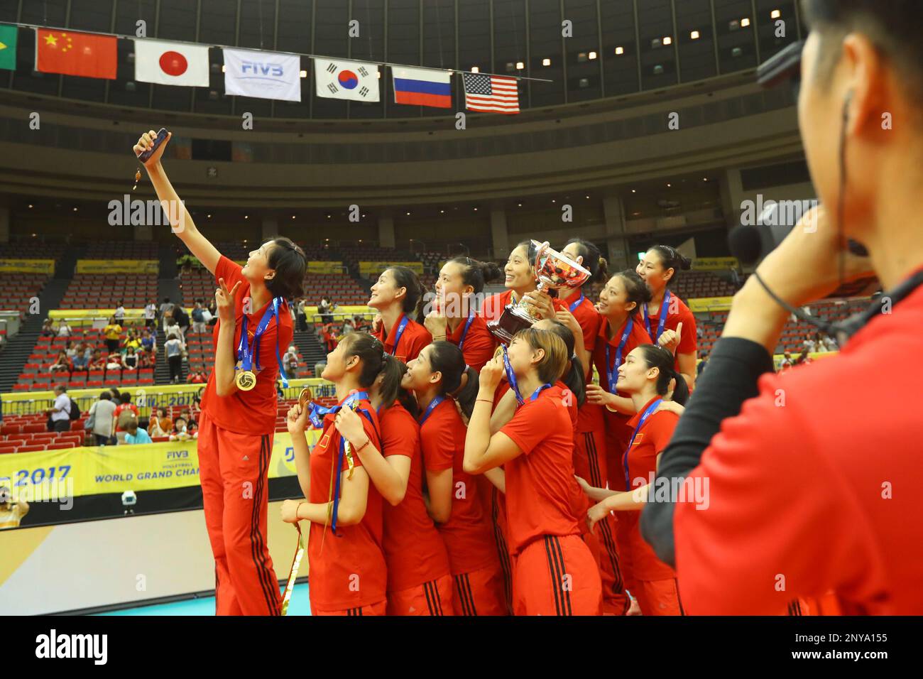Winner the Chinese women's national volleyball team members pose for selfies with their trophy