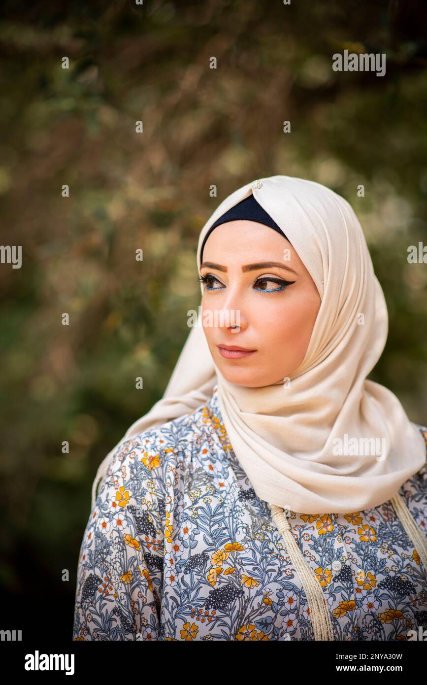 Pensive Muslim woman looking away outdoors Stock Photo