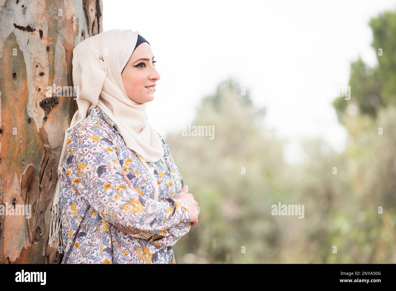 Happy Muslim woman looking away outdoors Stock Photo