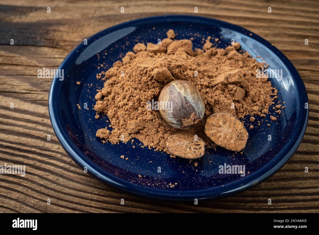 Nutmeg whole and grated in ceramic bowl Stock Photo Alamy
