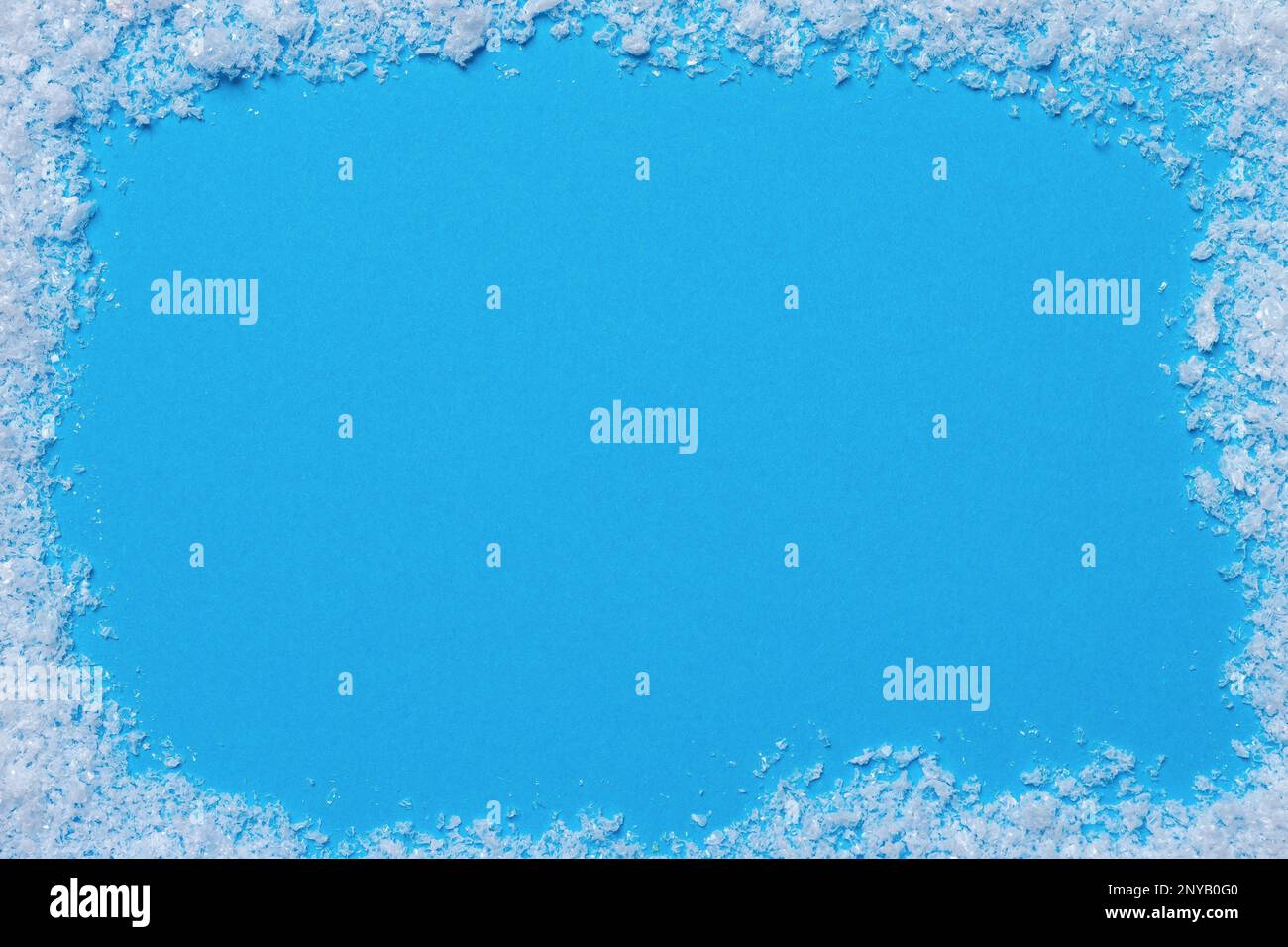 Blue blank space framed with artificial fake snow. Christmas greetings card concept. Copy space. Text space. Stock Photo