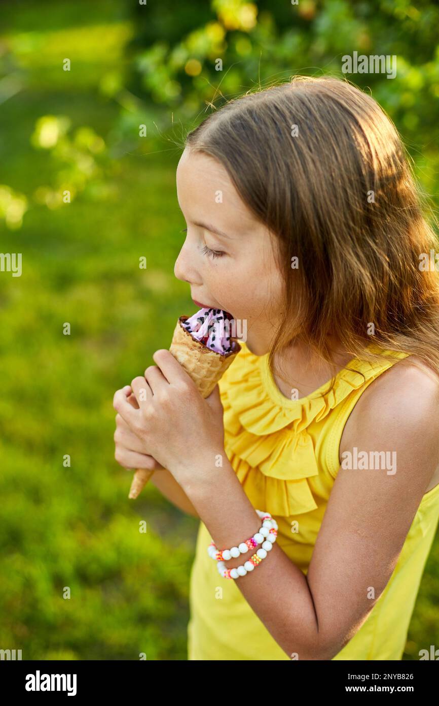 Happy girl with braces eating italian ice cream cone smiling while