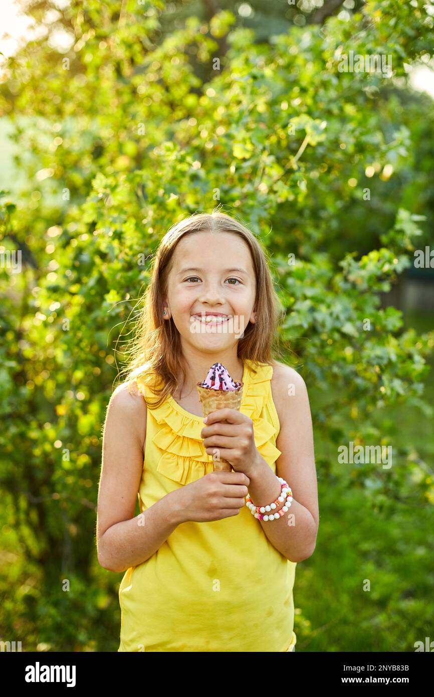 Happy girl with braces eating italian ice cream cone smiling while