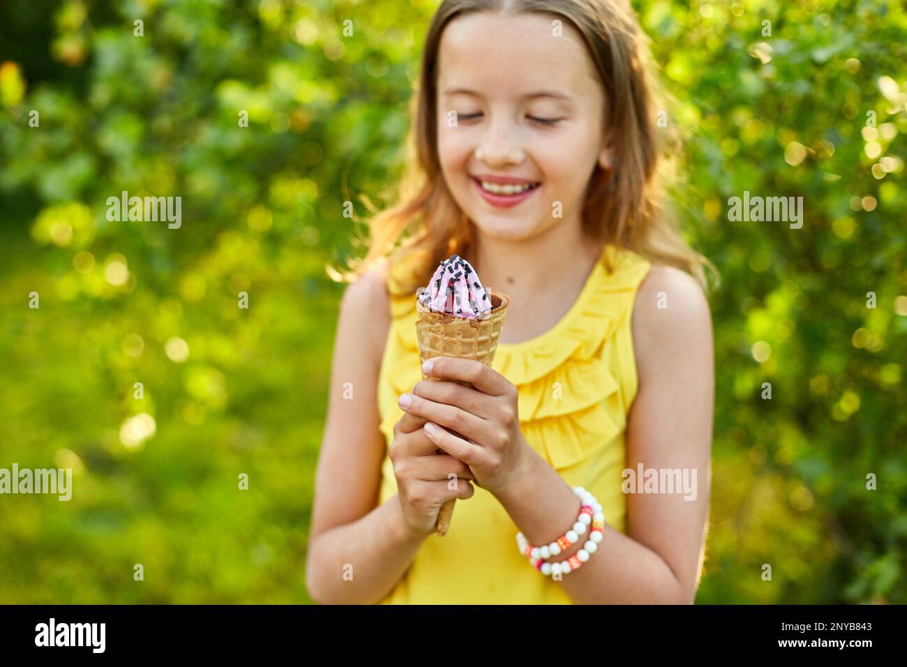 Happy girl with braces eating italian ice cream cone smiling while