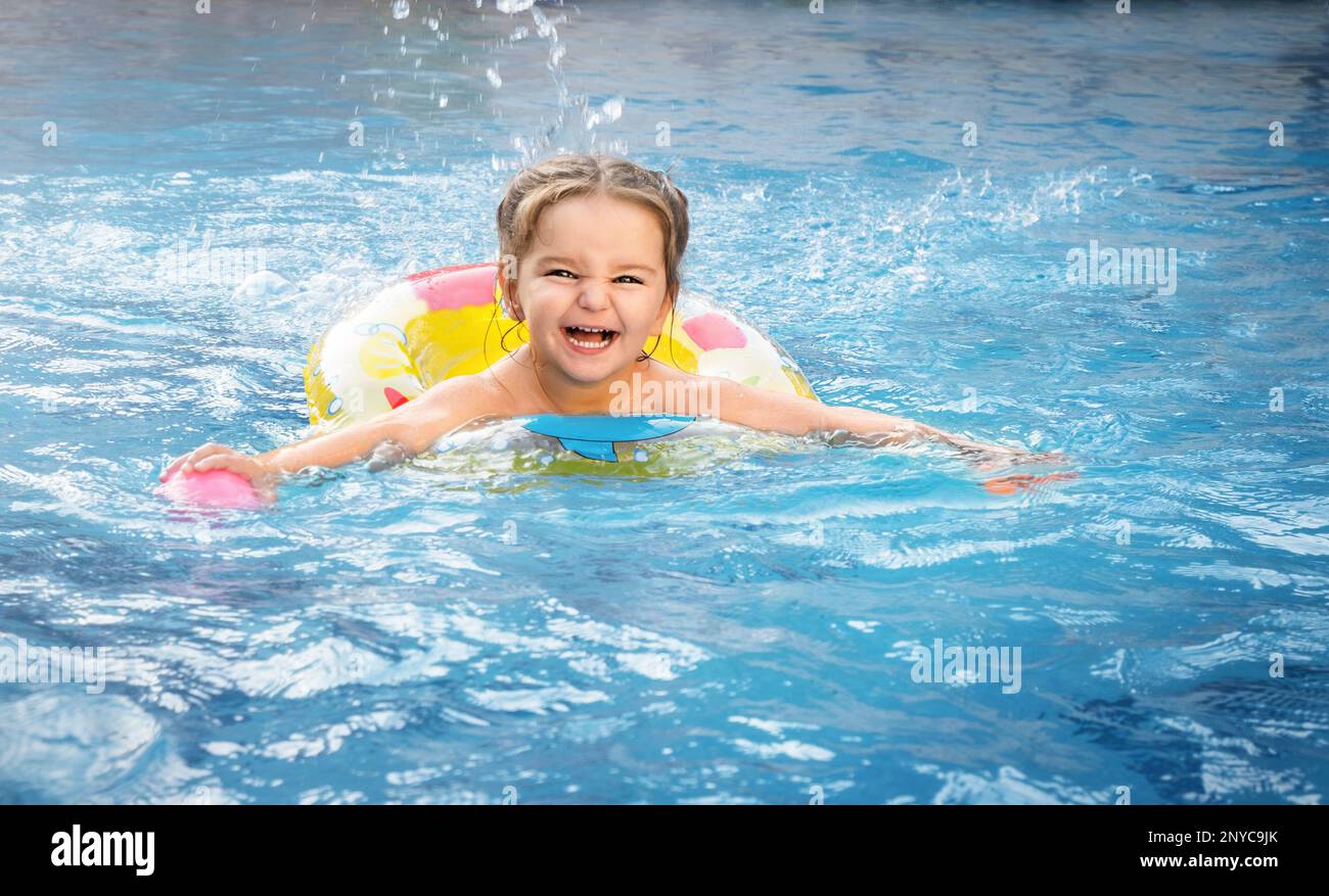 Happy child swims in the pool on vacation Stock Photo